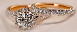 a diamond studded gold ring set with a circle cut center diamond