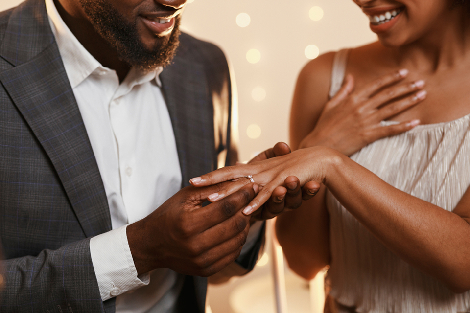 a man putting an engagement ring on a womans finger