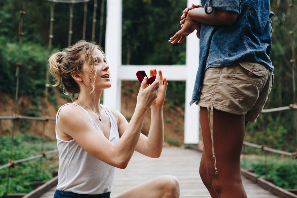 a woman proposing to her happy girlfriend