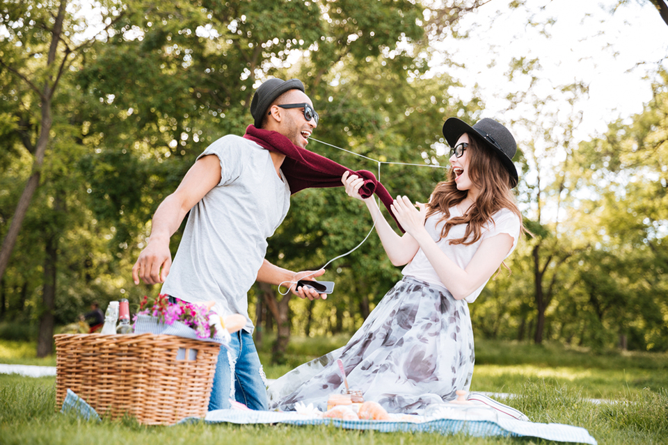 a young couple having fun together while picknicking