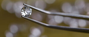 closeup tweezers holding diamond