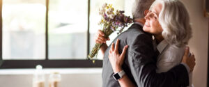 Young attractive Asian couple, man wearing white shirt, woman wearing white dress with wedding veil holding bouquet of flowers together. Concept for pre wedding photography.