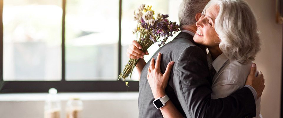 Young attractive Asian couple, man wearing white shirt, woman wearing white dress with wedding veil holding bouquet of flowers together. Concept for pre wedding photography.